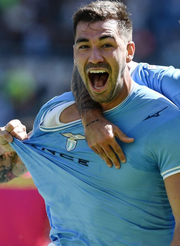 Una foto del difensore Alessio Romagnoli con la maglia della Lazio, con un'espressione decisa, durante un'intervista o un allenamento.