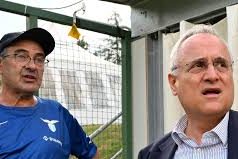 Lotito (Presidente Lazio) a DAZN: “Fiducia e Unione. Stiamo Definendo per lo Stadio Flaminio. Mercato? Faremo il Necessario” Claudio Lotito, Presidente della Lazio, mentre parla con un microfono di DAZN a bordo campo prima di una partita, con un'espressione decisa e fiduciosa.