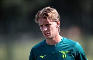 Caso Rovella–Lazio: la frattura comunicativa che preoccupa Niccolò Rovella in maglia Lazio, pensieroso a bordo campo, durante un momento di pausa.