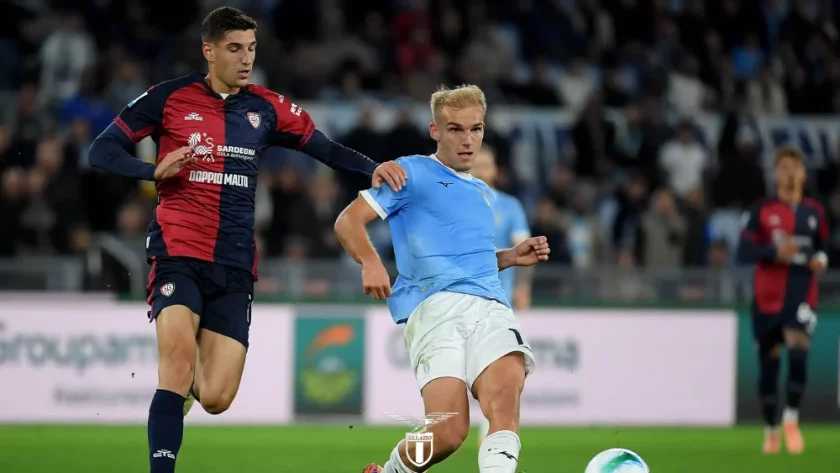 Gustav Isaksen, calciatore della Lazio e della Nazionale danese, con un'espressione determinata e positiva, magari in un'immagine composita che unisce elementi di Lazio e Danimarca.