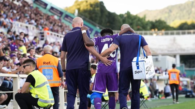 Giocatore di Serie A a terra infortunato con staff medico che interviene