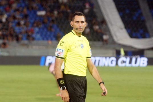 Lazio scrive alla Lega: “Serve chiarezza sugli arbitri” L'arbitro Colombo con un'espressione preoccupata durante una partita, con i loghi dei principali quotidiani sportivi italiani sullo sfondo.